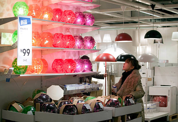 Jeune femme qui choisit une lampe dans un magasin de luminaires